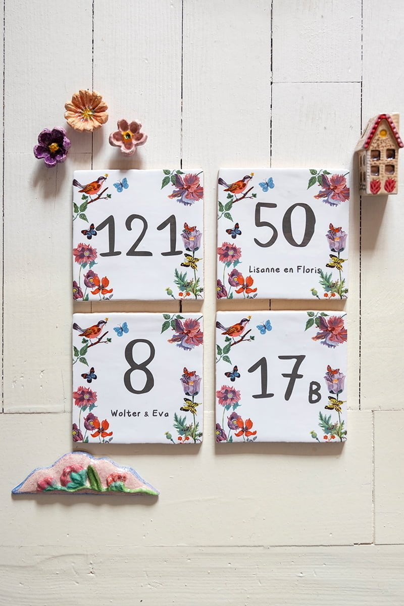 Tegeltjes met huisnummers en bloemen op witte achtergrond