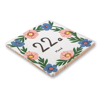 Huisnummer tegeltje met roze en blauwe bloemen rondom nummer