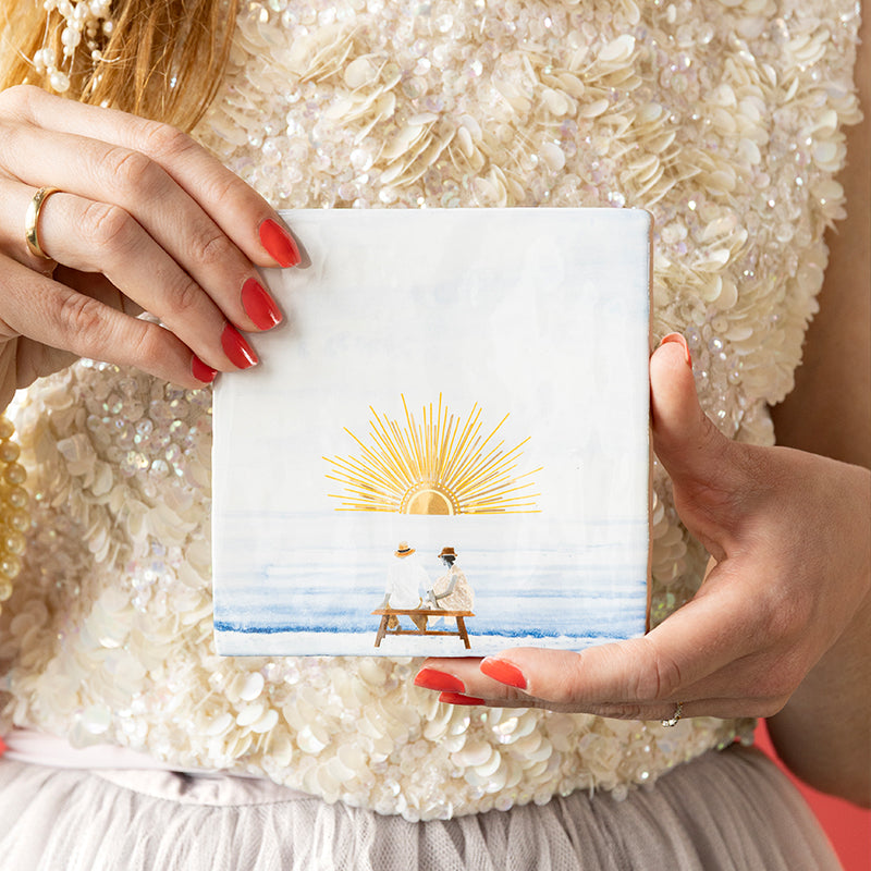 StoryTile met gouden zon en stel dat naar de zonsondergang kijkt