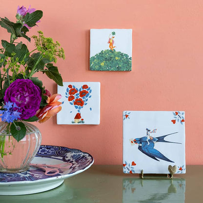Bloemrijke tegeltjes met illustraties aan roze muur gepresenteerd