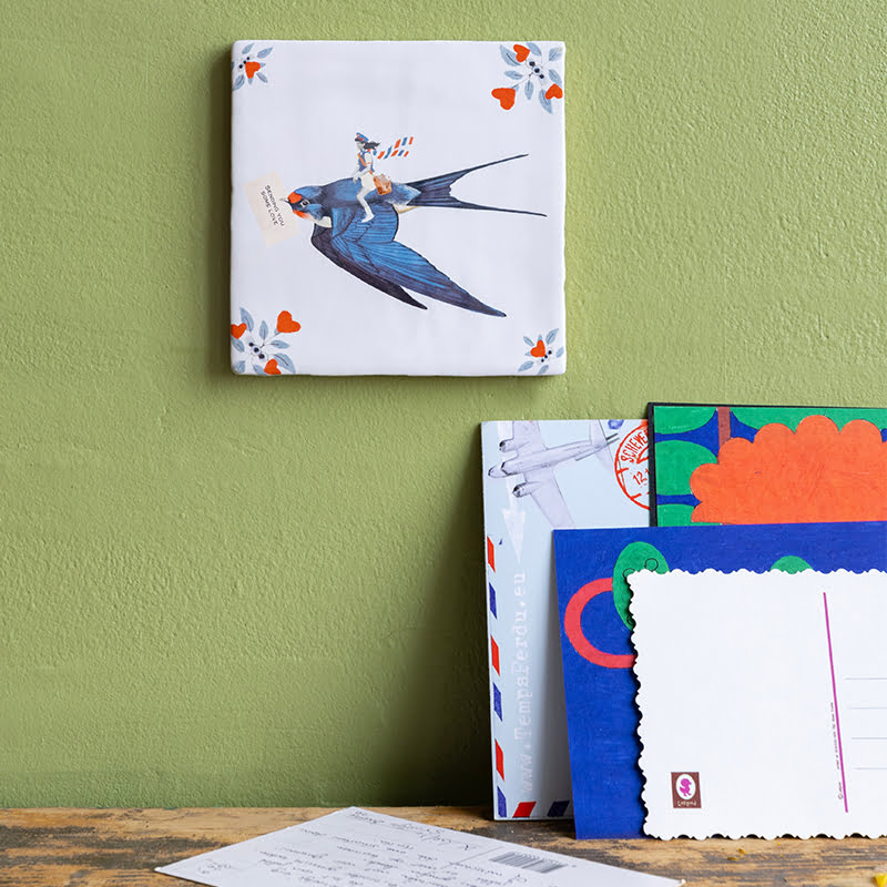 Gepersonaliseerd tegeltje met vogelmotief, op groene muur gepresenteerd