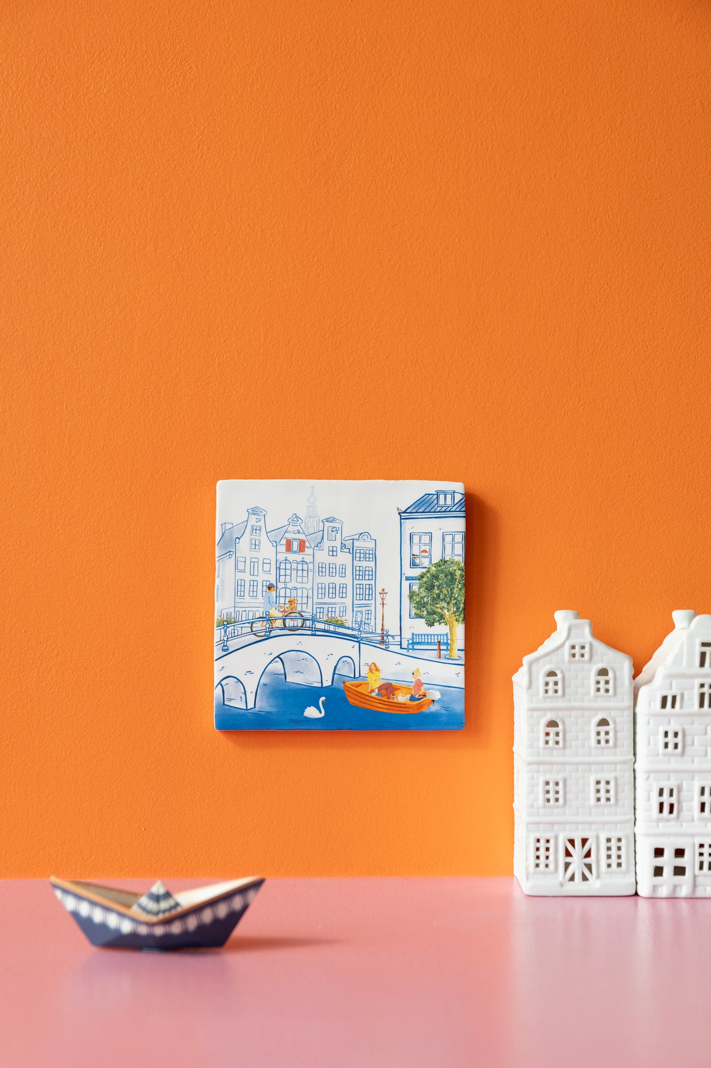 Kleurrijke tegel met een pentekening van Amsterdamse huisjes en gracht met brug