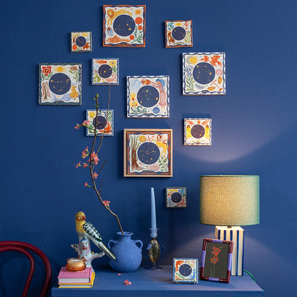 alle twaalf sterrenbeelden in verschillende maten en hoogtes op een blauwe muur gehangen