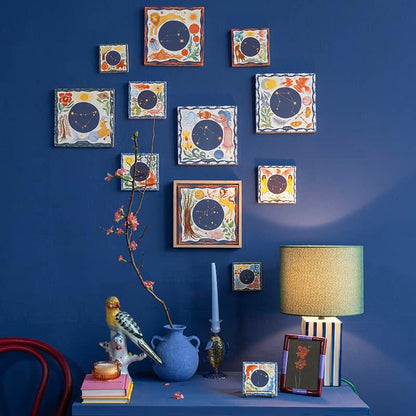 Geboortetegels met sterrenbeeldmotieven aan een blauwe muur