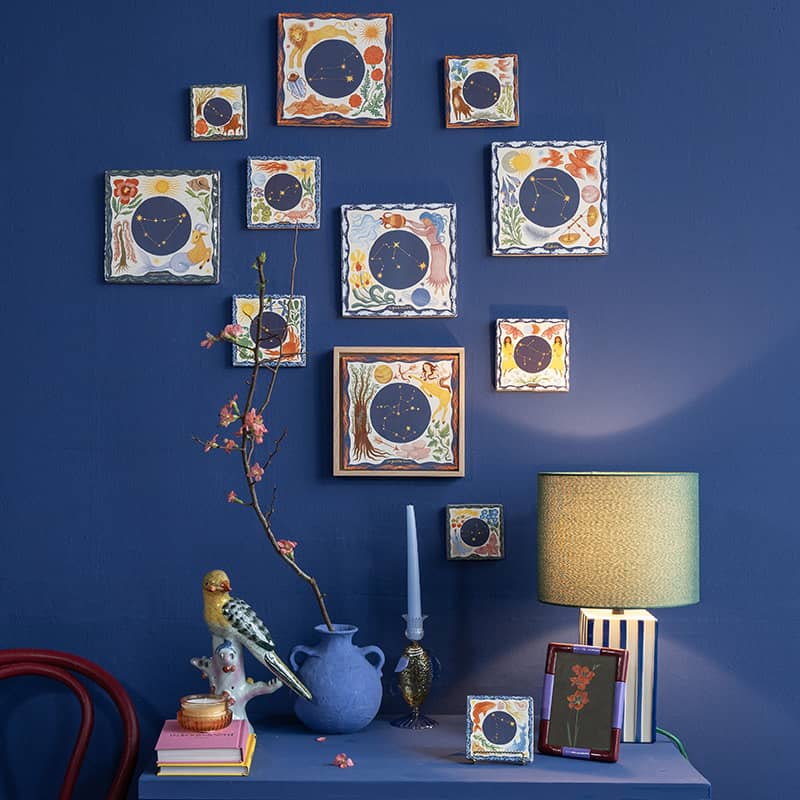 Geboortetegeltjes met sterrenbeelden aan blauwe muur gepresenteerd