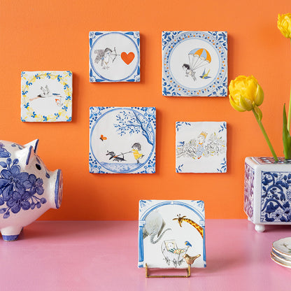 De StoryTiles collectie tegeltjes met Fiep Westendorp ontwerpen op een oranje muur