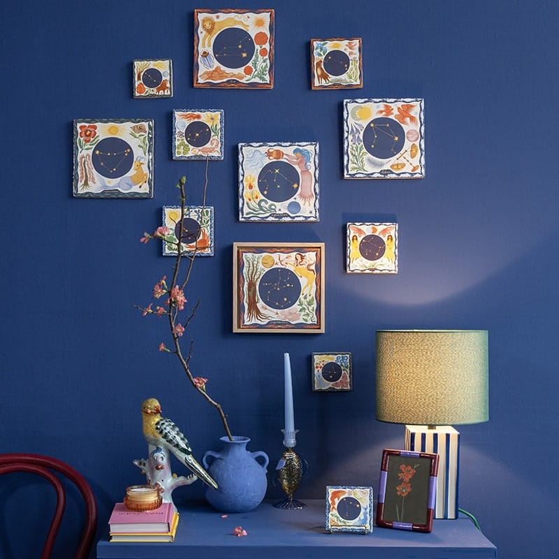 Geboortetegeltjes sterrenbeelden op kleurrijke muur als kunstgalerij in huisdecor