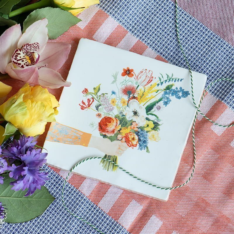 Bloemenegeltje met boeket bloemen op gekleurde stoffen achtergrond