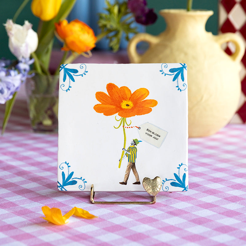 Gouden houder met een hartje met daarin een tegel met een man die een grote rode bloem draagt