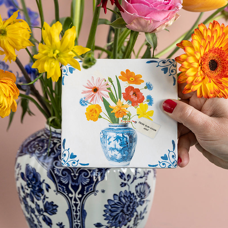 Bos gekleurde bloemen in een Delfts blauwe vaas met kaartje met eigen tekst eraan