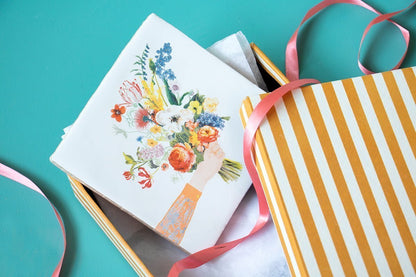 Tegeltje met bloemenboeket in gestreepte geschenkdoos gepresenteerd