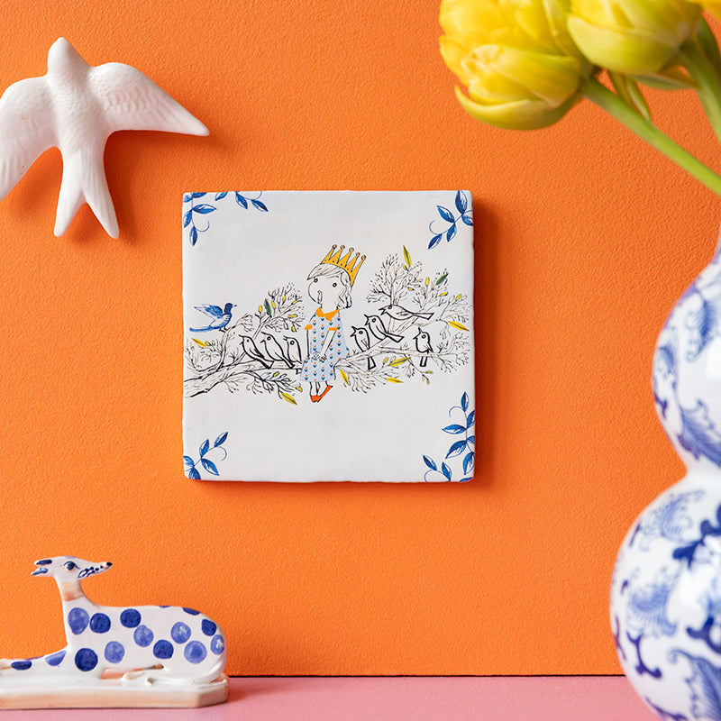 Fiep Westendorp tegeltje meisje met Vogelkoortje hangend aan een oranje muur
