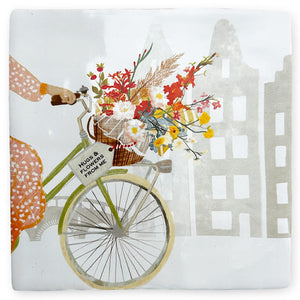 Gepersonaliseerd tegeltje met fiets en bloemen voor huisjes op de achtergrond